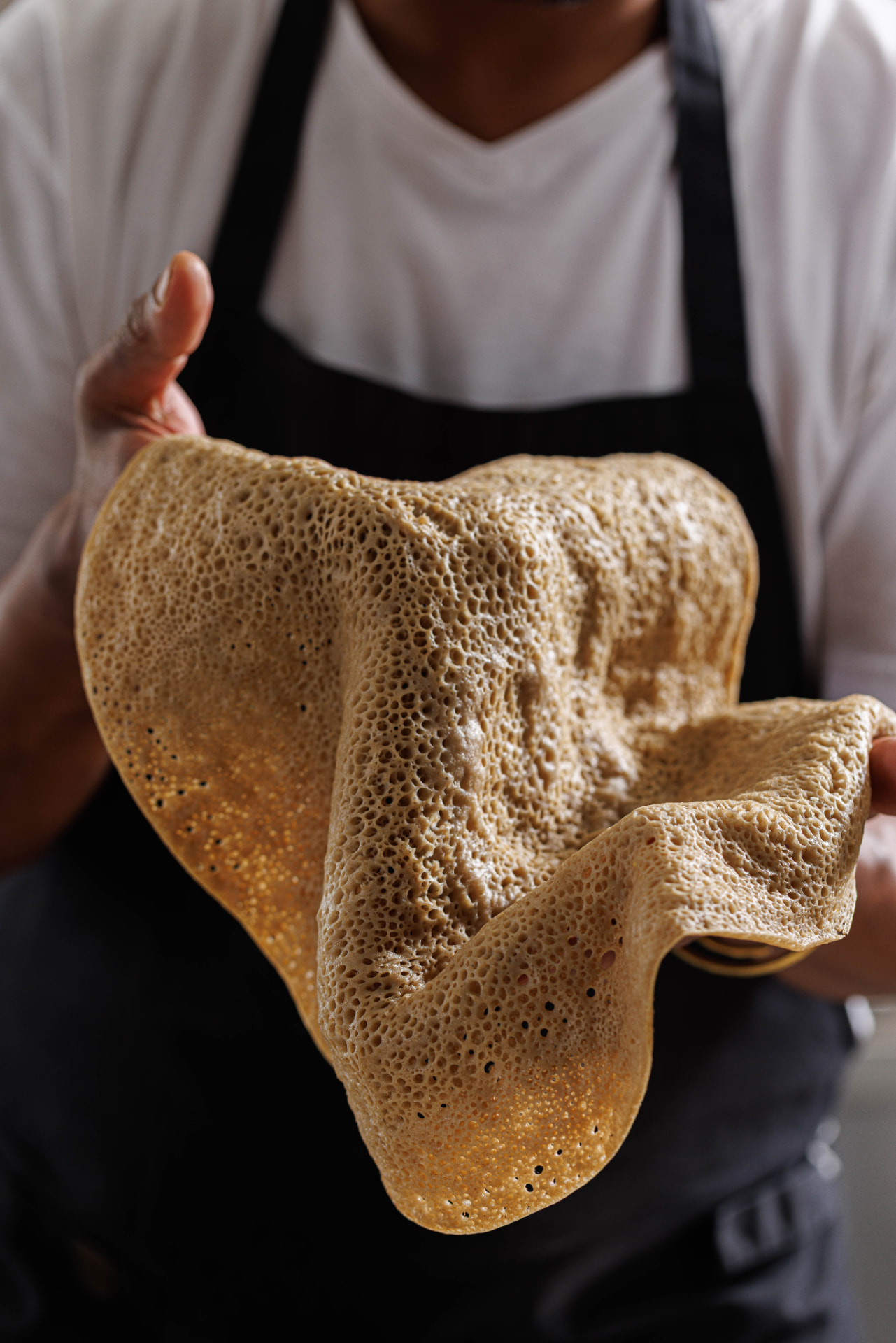 Hands holding fresh injera